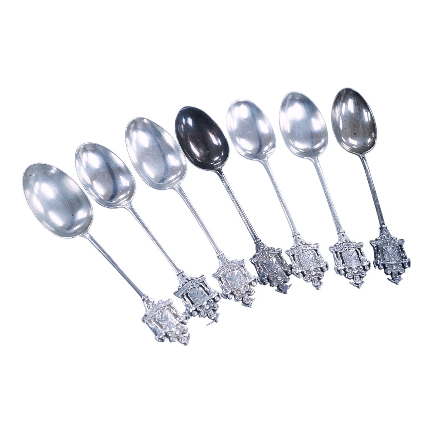 A matched set of seven early 20th century silver spoons, with rat-tail bowls, the terminals modelled as the crest of the Worshipful Company of Joiners and Ceilers, various dates and makers including Mappin & Webb and Elk